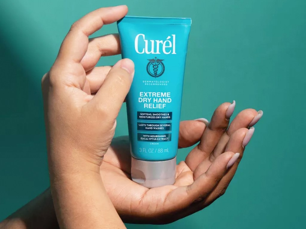 two hands holding blue bottle of Curél Extreme Dry Hand Cream