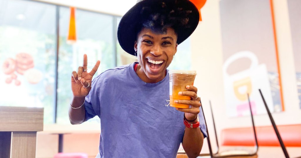 woman in dunkin donuts holding an iced coffee