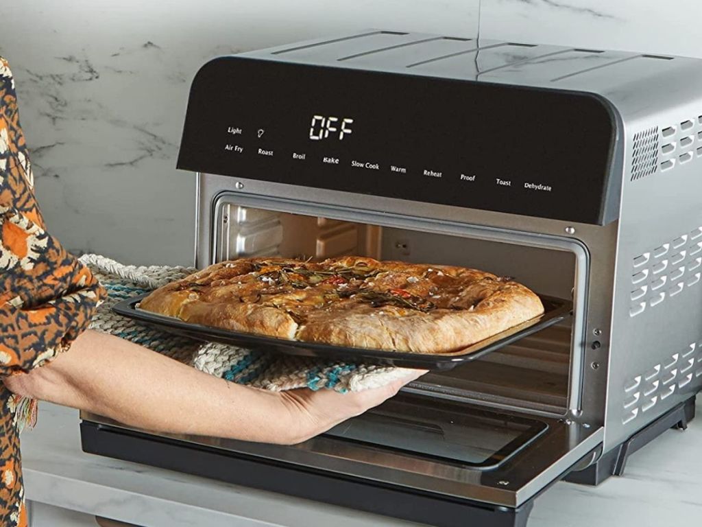 woman putting pizza into Instant Omni machine