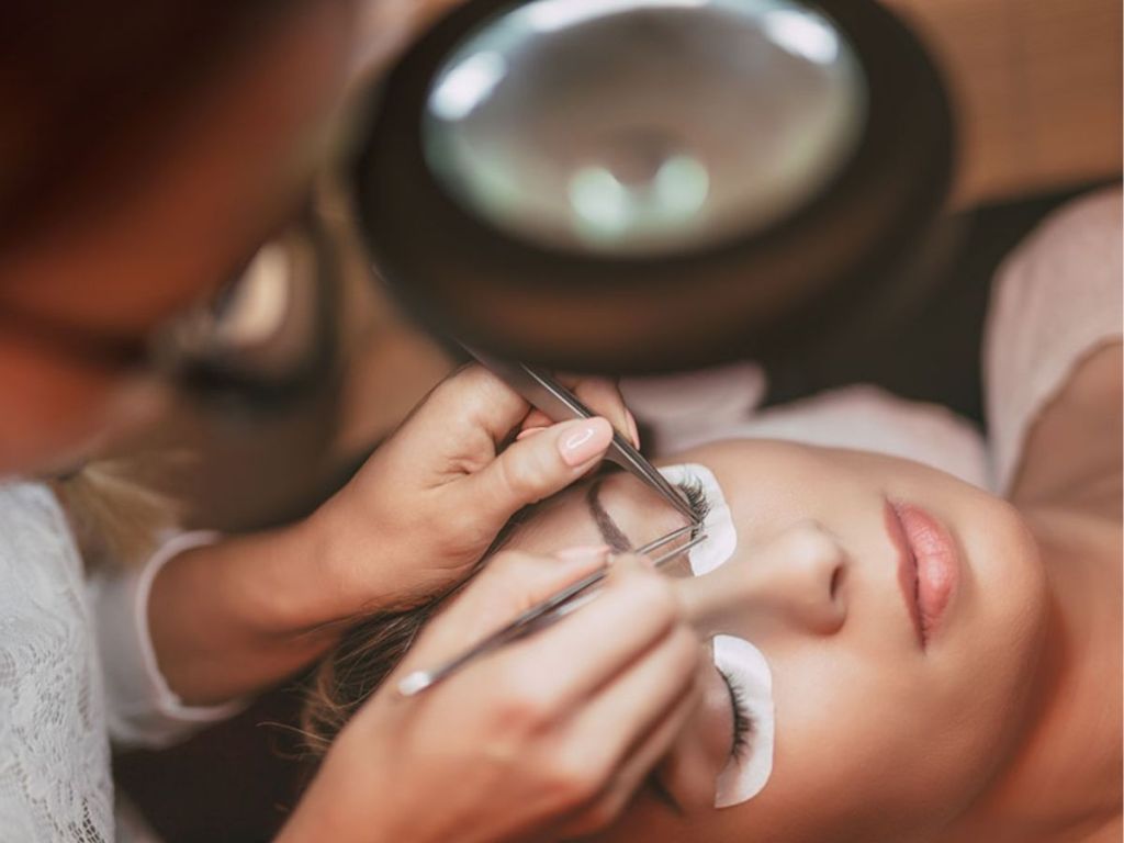 woman giving eyelash extensions