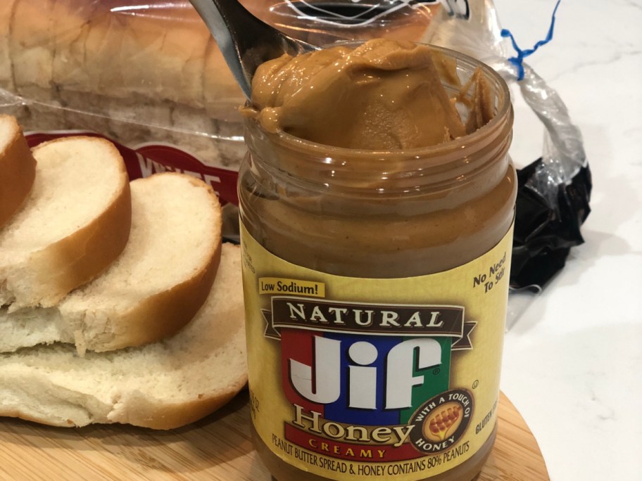 spoonful of Jif Honey Peanut Butter next to white bread slices