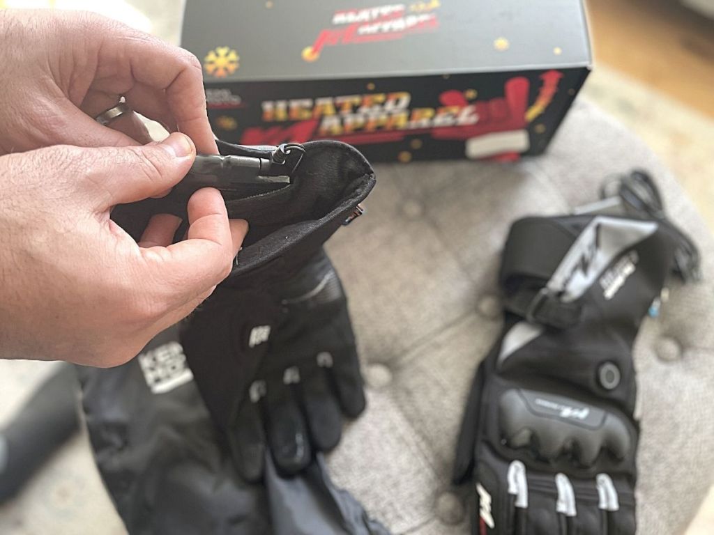 man putting battery in Kemimoto Rechargeable Waterproof Heated Gloves