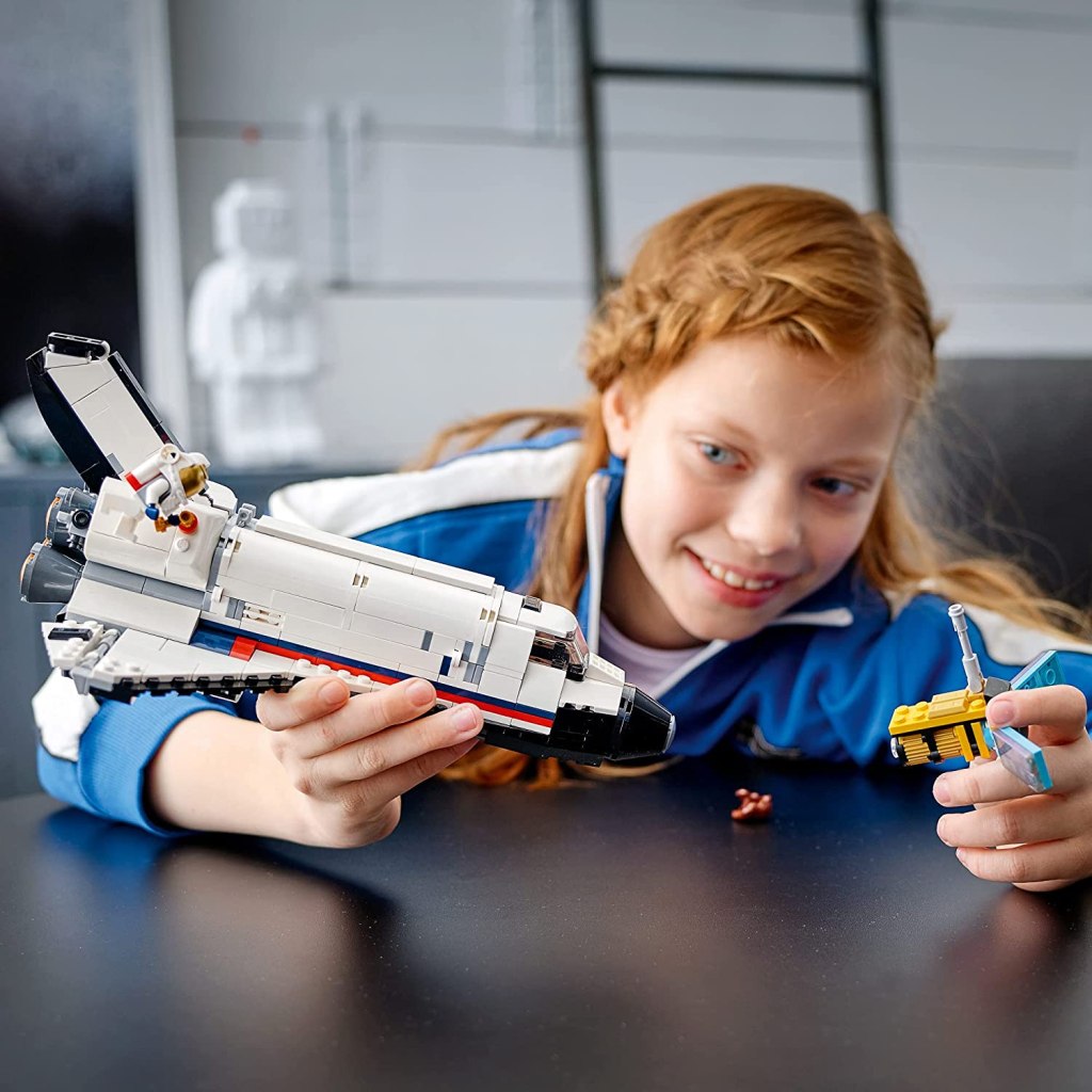 girl playing with LEGO Creator 3in1 Space Shuttle Adventure