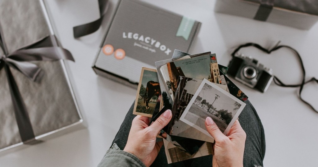 hands holding polariod photos over legacy box