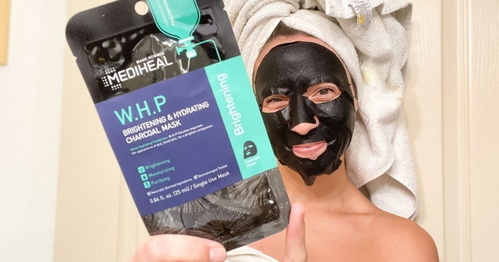 woman in face mask holding up Mediheal WHP Charcoal Facial Masks