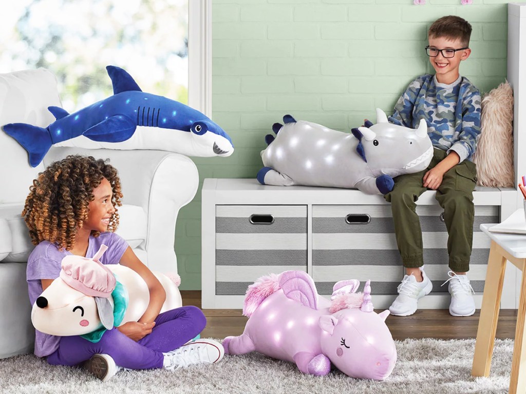 two kids in playroom with large light up animal pillows