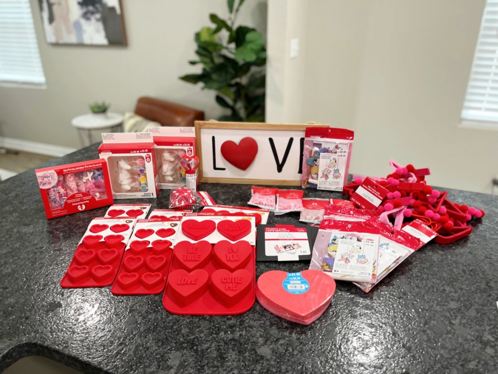 large pile of Valentine's Day decor, baking supplies and more on kitchen counter