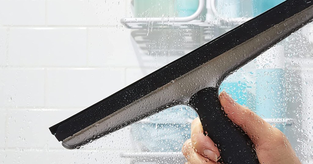 OXO stainless steel squeegee being used on a wet shower door