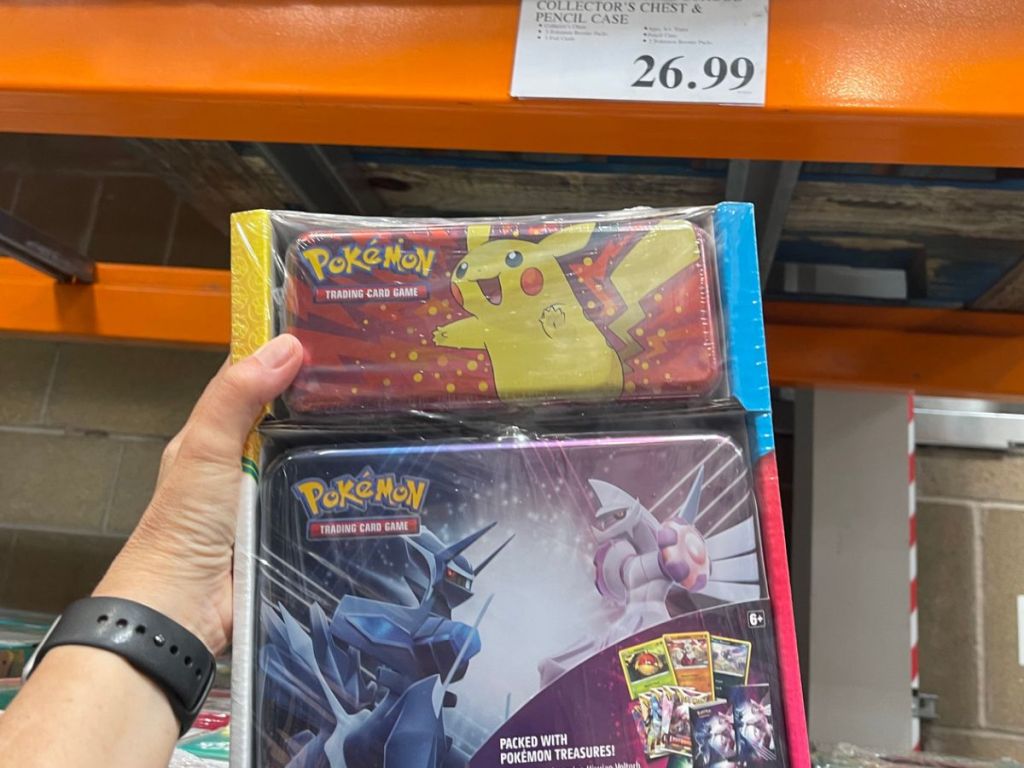 A hand holding Pokemon pencil box and collector's chest 