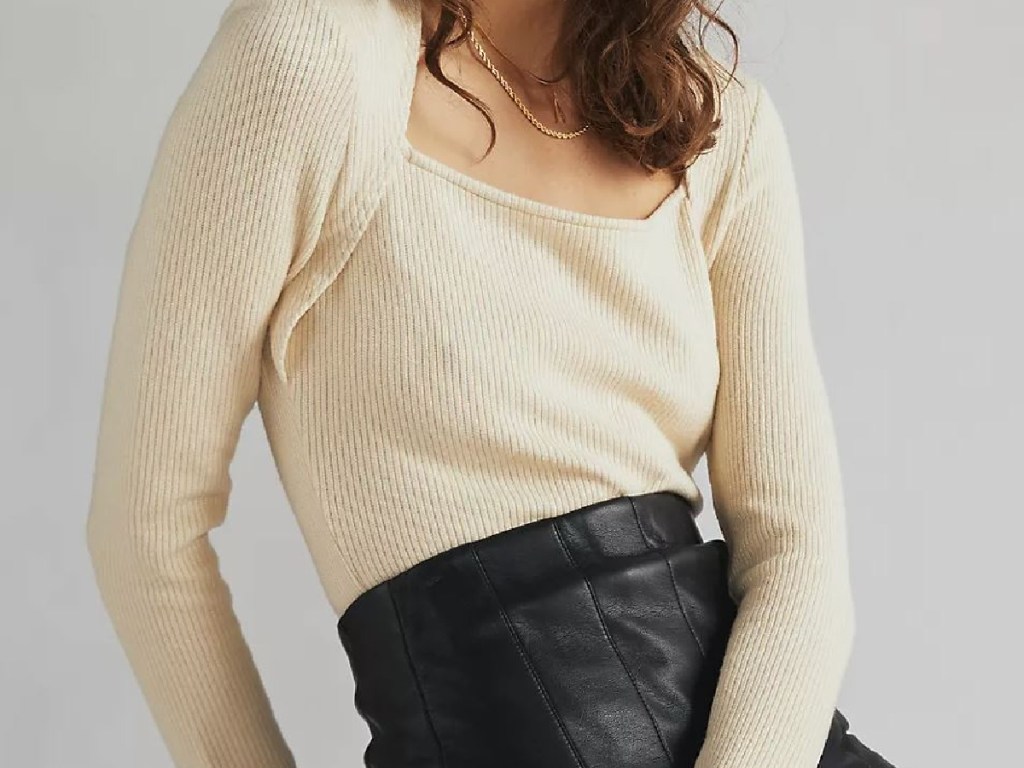woman's torso wearing cream colored top sweater