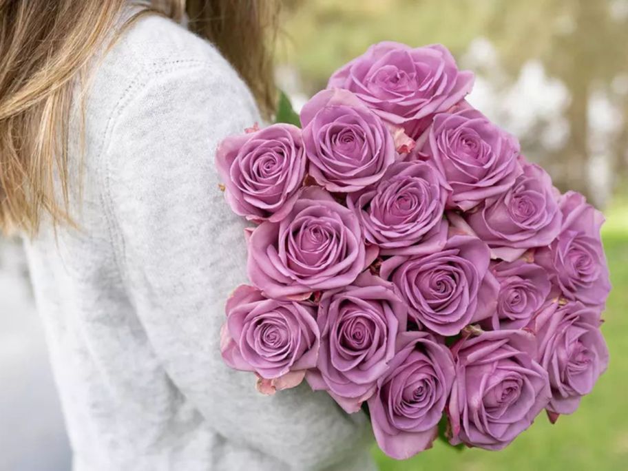 Woman holding a bouquet of lilac color roses