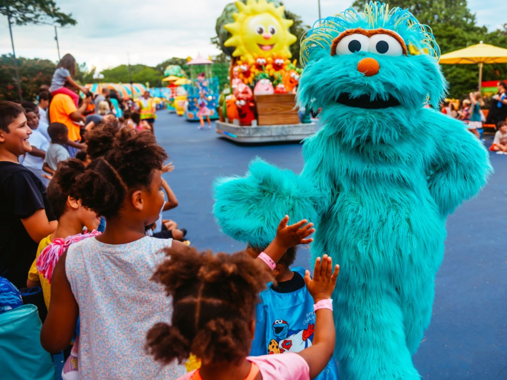 kids high-fiving Sesame Street character at Sesame Place