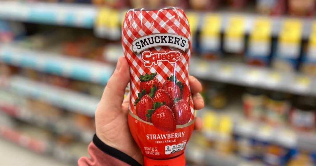 hand holding jar of strawberry jelly 