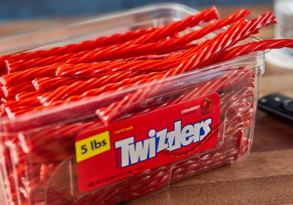 large open plastic container of red twizzlers