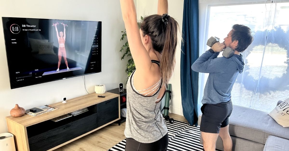 man and woman exercising in living room
