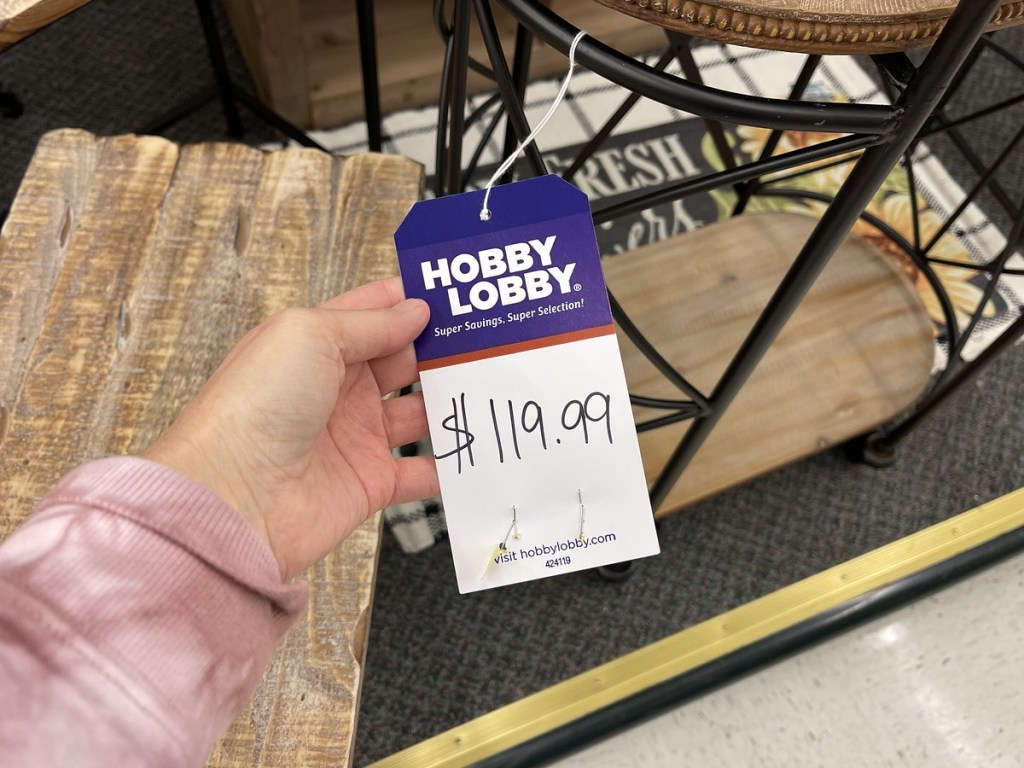 holding a furniture price tag at Hobby Lobby
