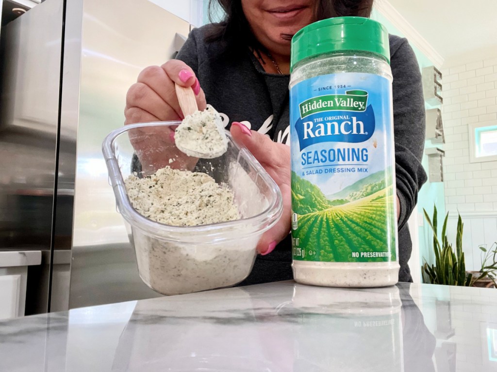 Holding homemade ranch seasoning next to a store bought shaker. 