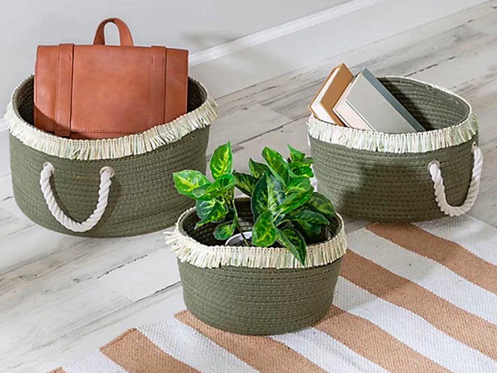 three green and beige rope baskets with plant, purse and books inside them