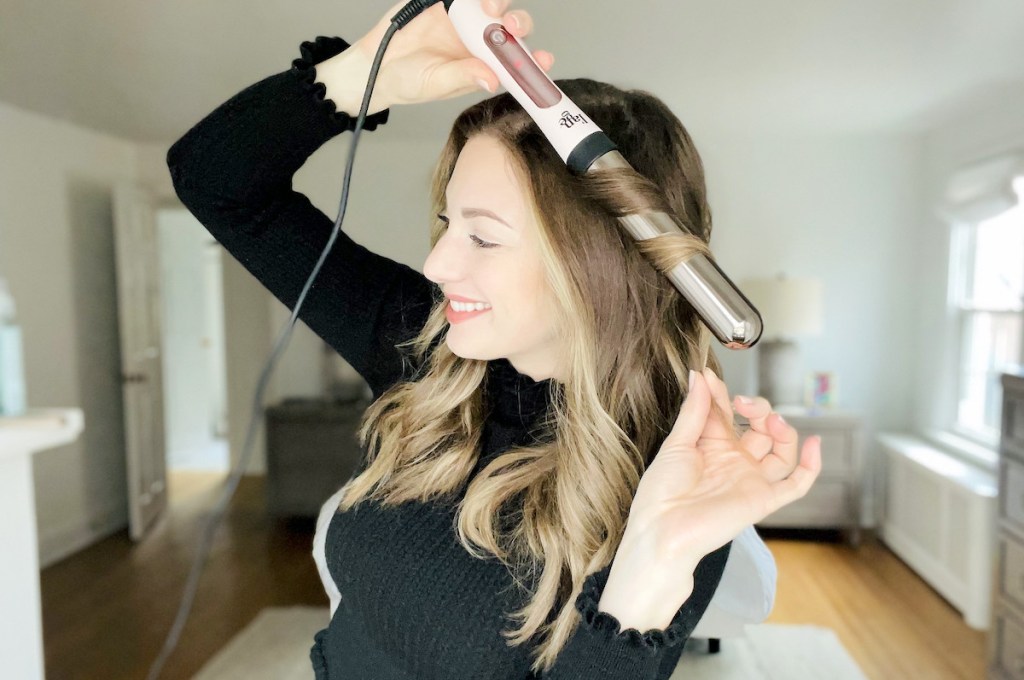 woman holding curling wand on hair
