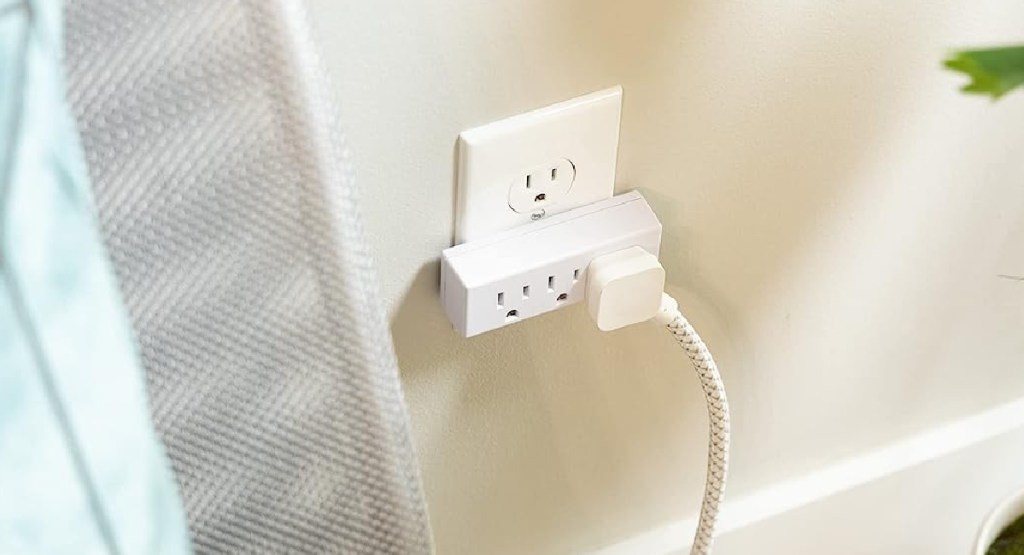outlet extender displayed ay the wall with plant behind it