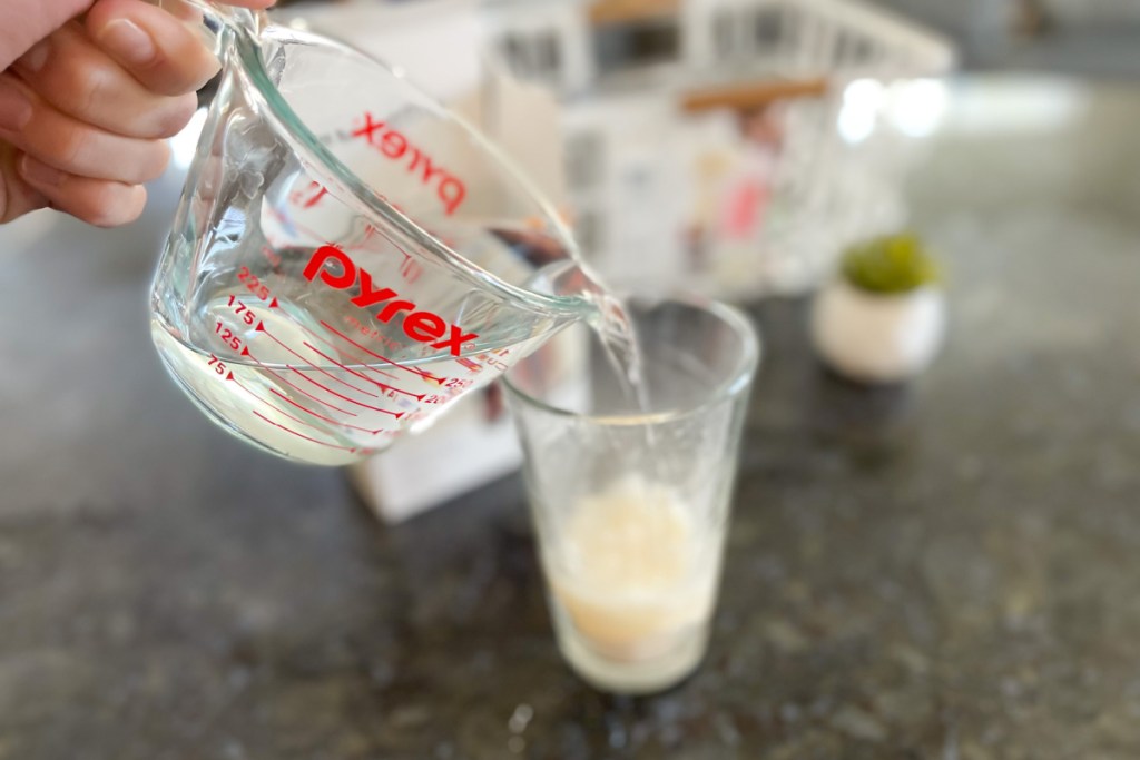 pyrex pouring water into protein powder