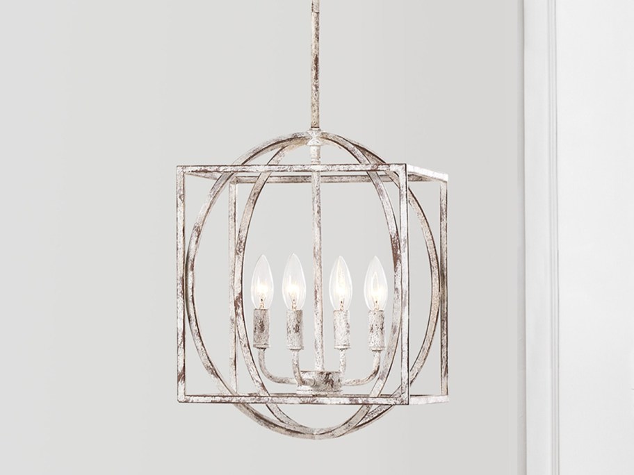 silver light pendent with lights inside displayed on gray walls