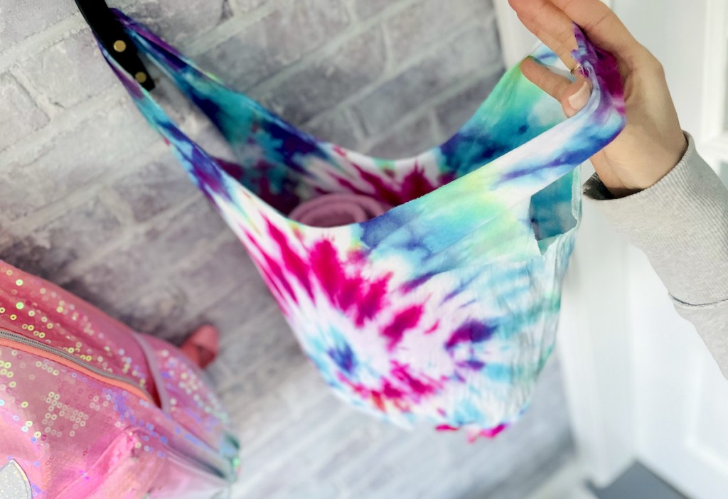 hand holding open tie dyed bag