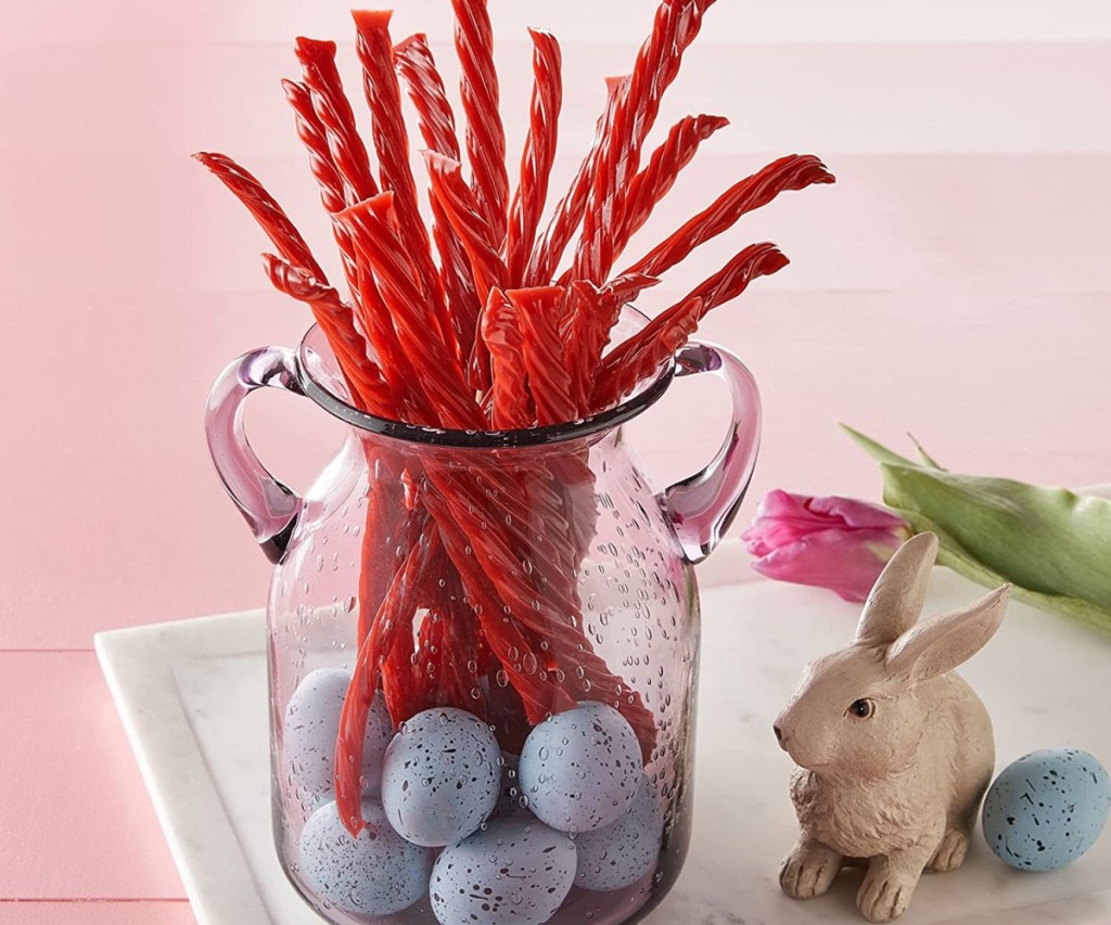 twizzlers candy in a glass container surrounded by Easter decor