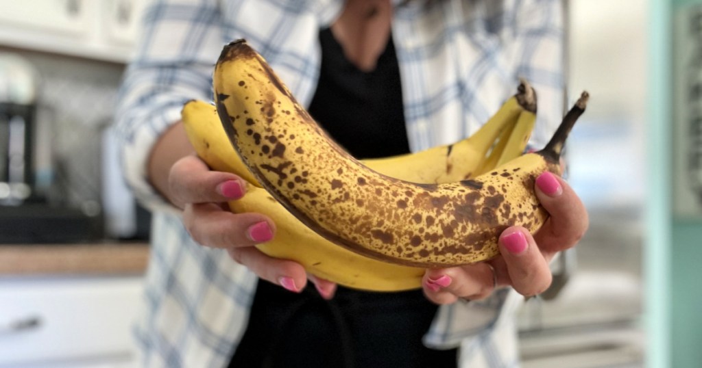 woman holding browned overripe bananas