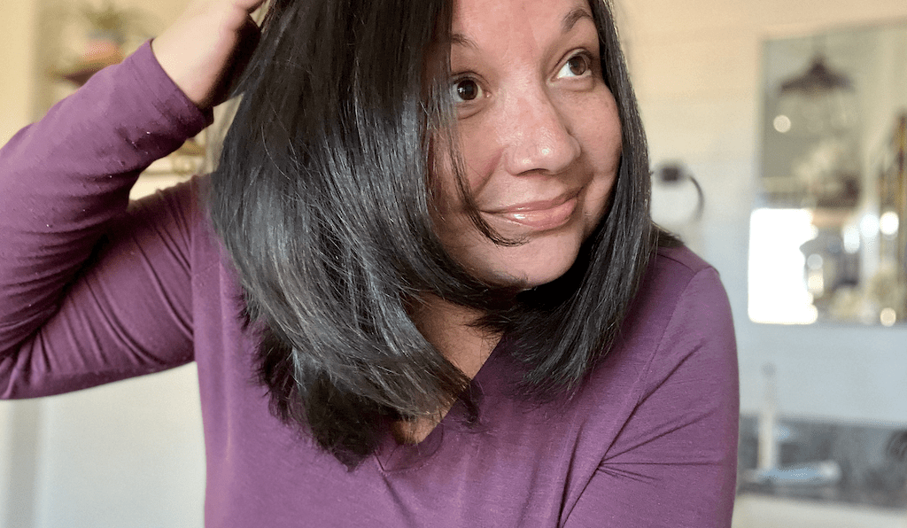 woman showing beautiful hair using the L'ange dryer brush