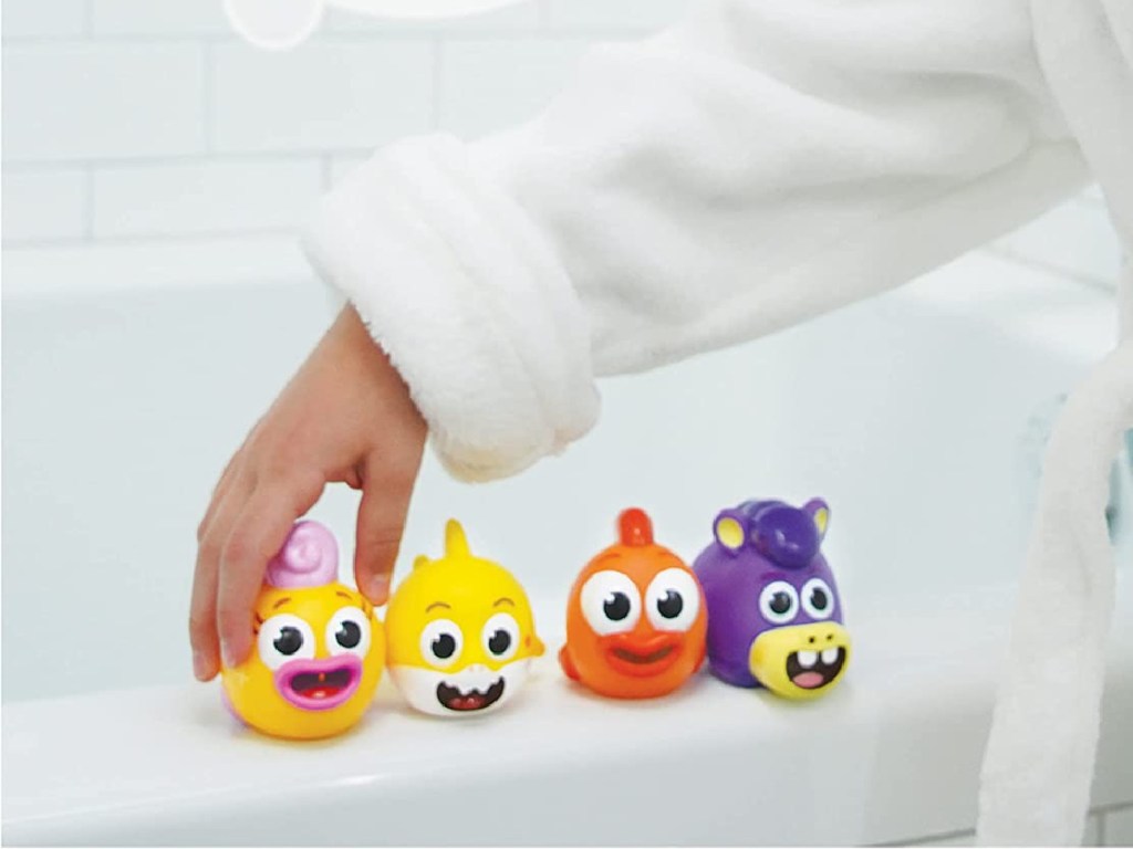 four character squirt toys on bathtub ledge