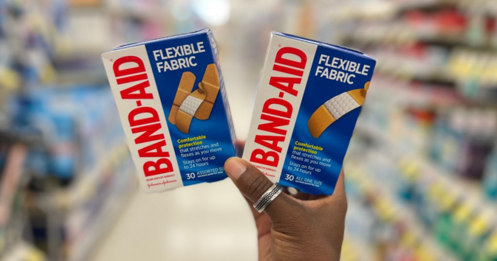 hand holding two boxes of band-aid bandages in store