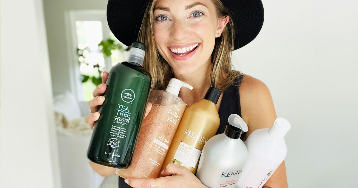 woman holding arm full of haircare products