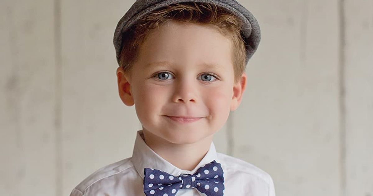 little boy wearing gray driver cap and polka dot bowtie