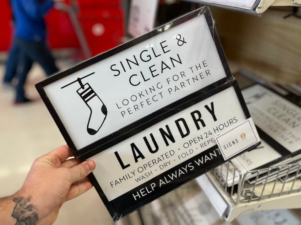hand holding pack of laundry wall signs in store