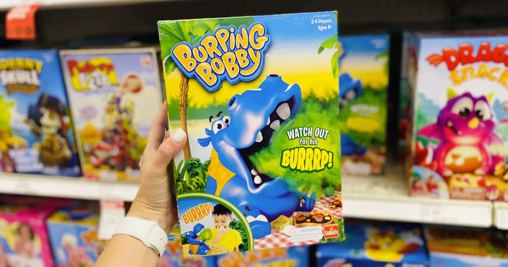 hand holding up the Burping Bobby Game box in store