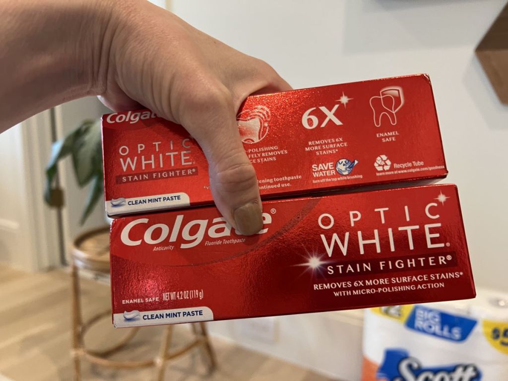 hand holding two boxes of toothpaste