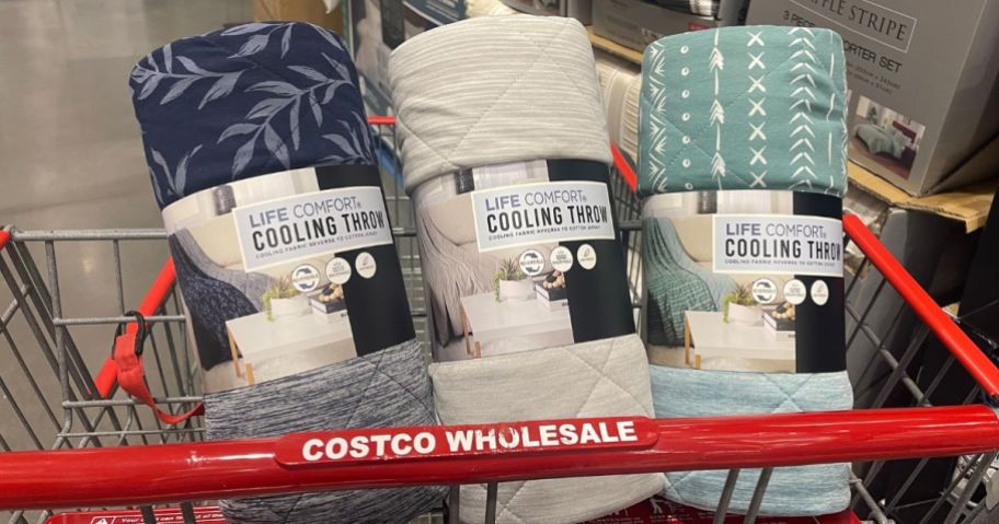 A costco shopping cart with 3 cooling blankets in the basket