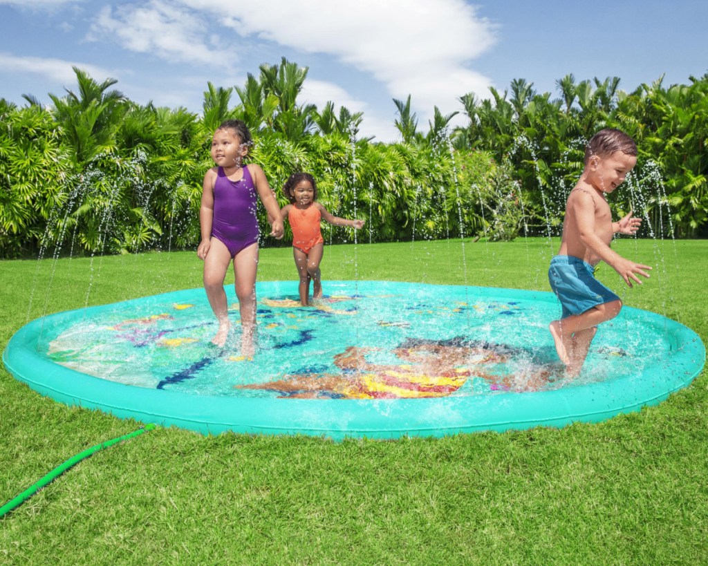 kids in swim suits playing on splash pad