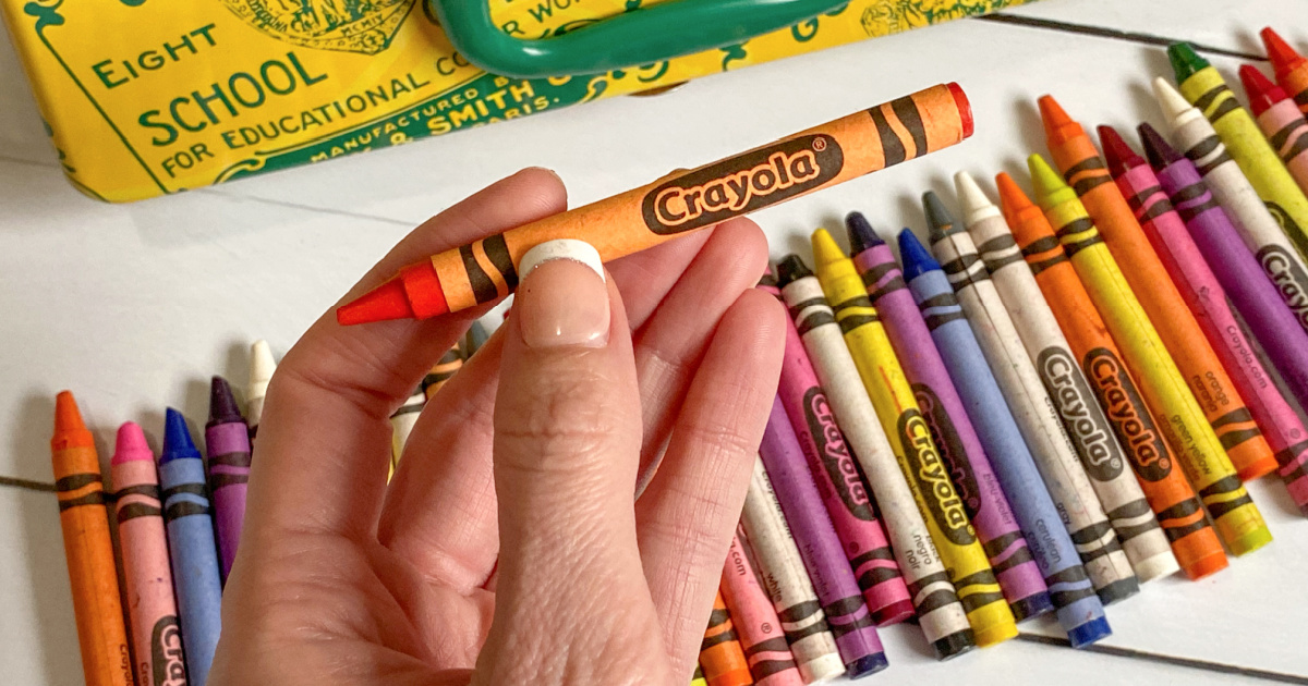 hand holding orange crayon