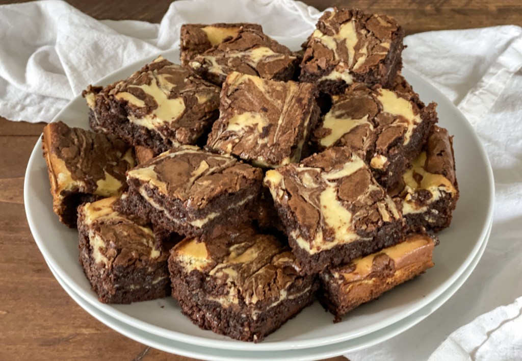 a plate stacked with cream cheese brownies 