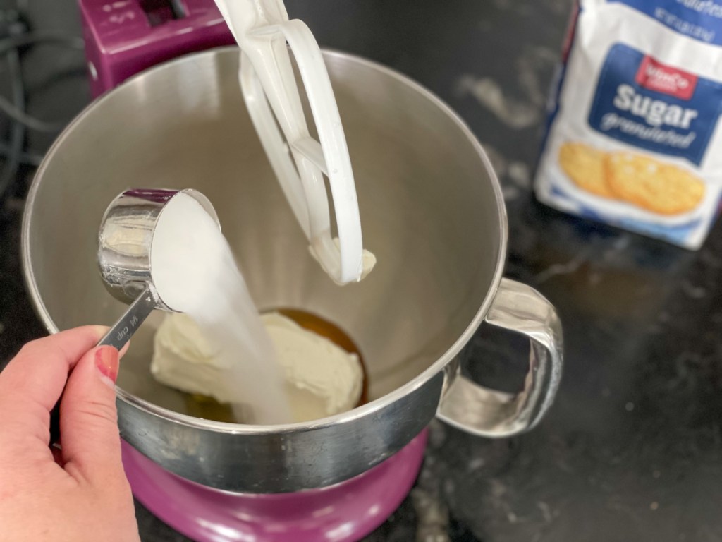 adding sugar to a mixer 