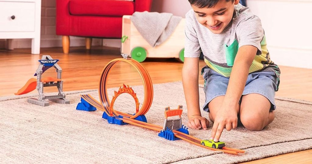 boy playing with a race car track