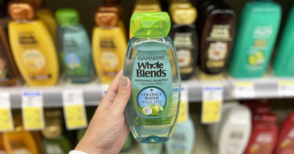 hand holding bottle of garnier whole blends shampoo