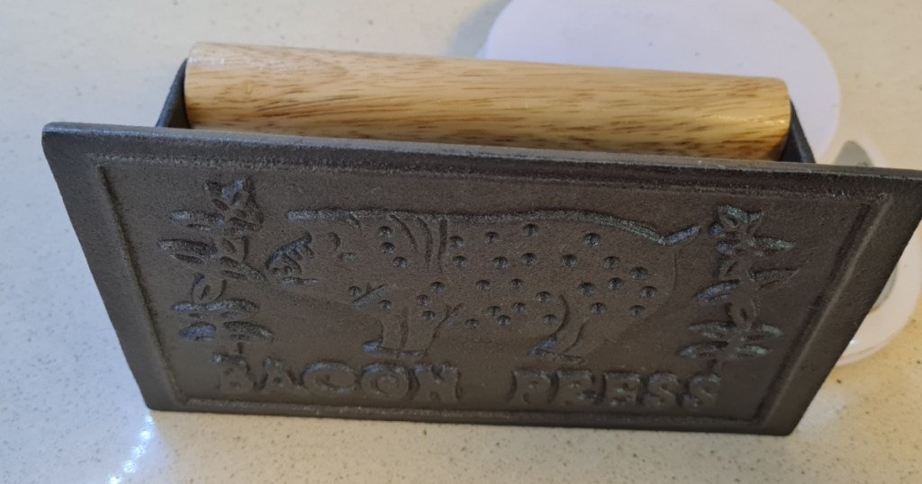 cast iron piece with picture of pig plus a wooden handle