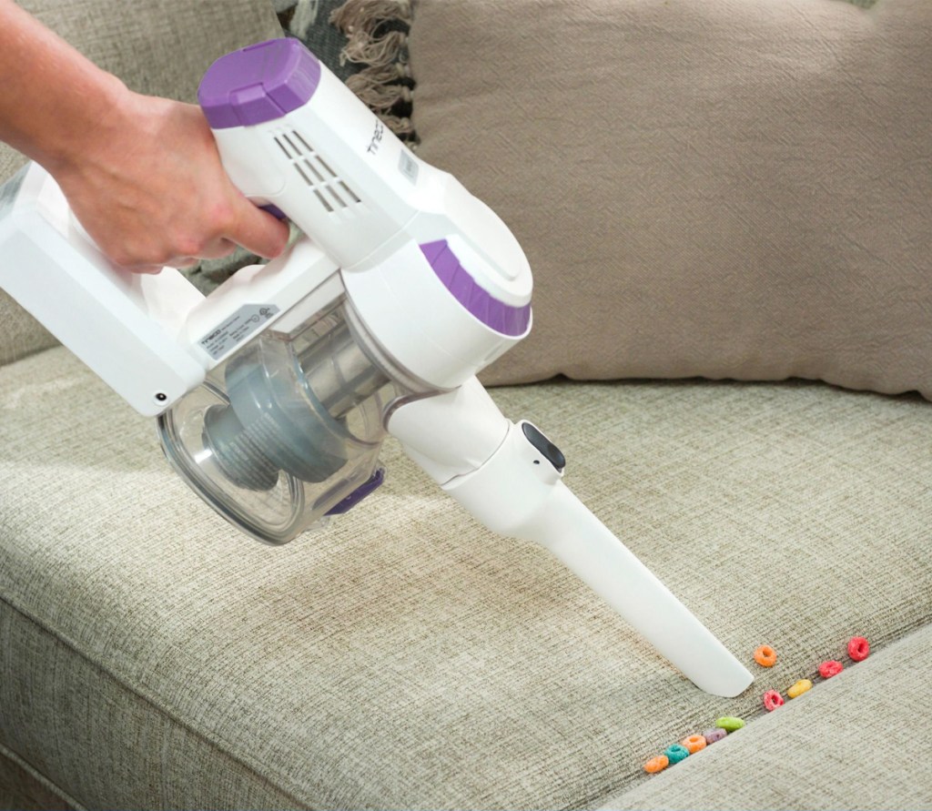 Tineco A10-D handheld vaccum cleaning up fruit loops in couch