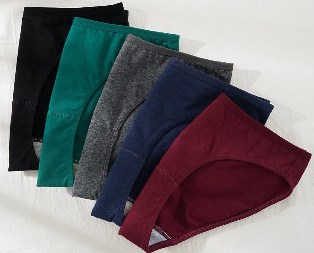 black, green, gray, blue, and burgundy folded undies on white sheet
