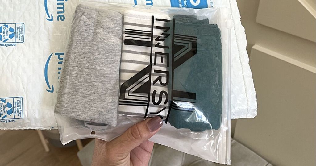 person holding Innersy package with gray, striped, and green folded undies in it