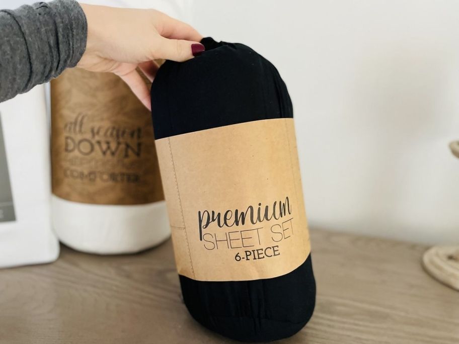 Linens & Hutch Premium Sheets Set in black with hand holding it 
