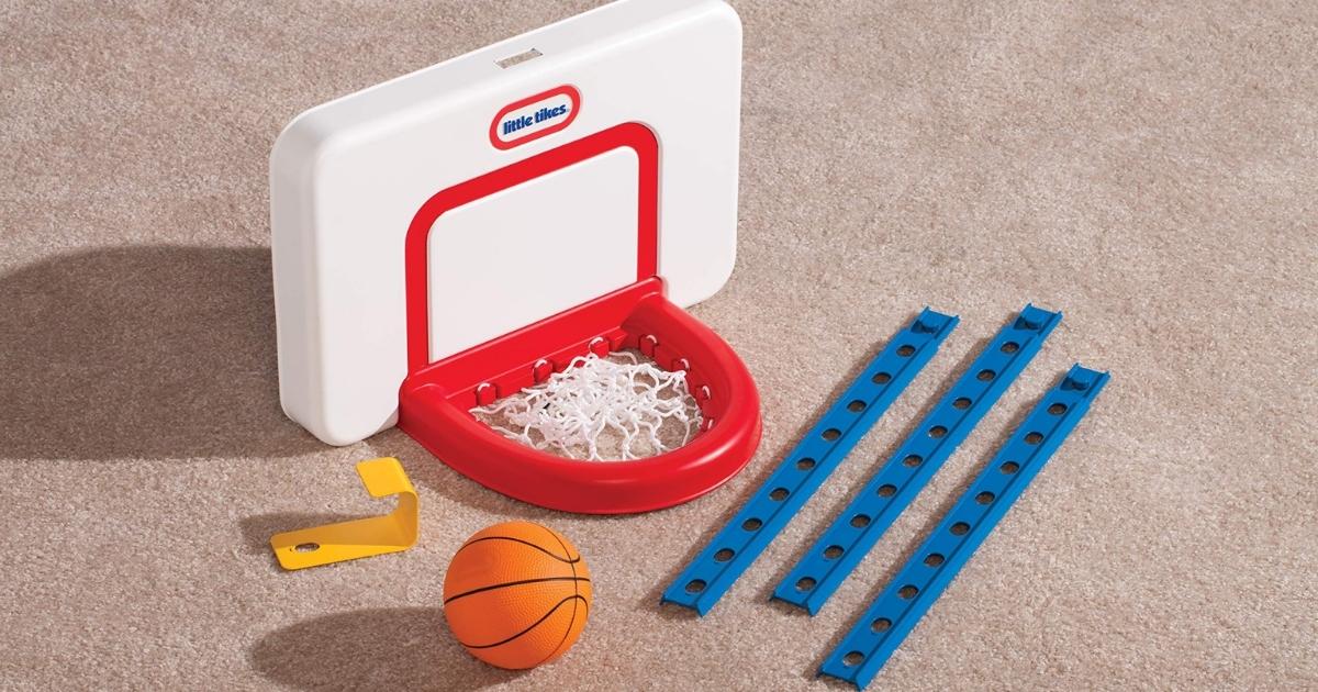 pieces of a little tikes basketball set laid out on a beige rug